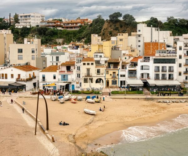 Explore the picturesque seaside town of Blanes, Spain, featuring vibrant architecture and a sandy beach.