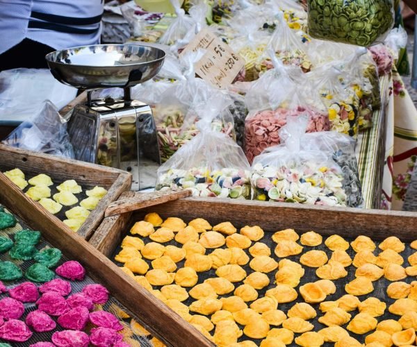 Colorful handmade pasta and market scene in Apulia, Italy showcasing local culture.